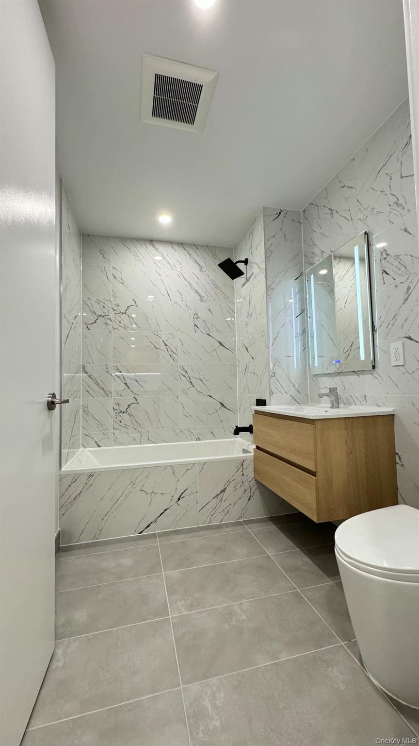 134-16 35th Avenue, Unit 6B Queens, NY 11354 - Photo 7 of 9 a bathroom with a bathtub and toilet