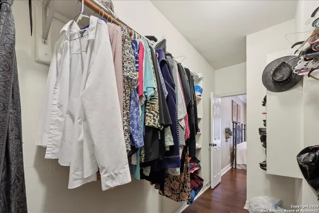 a view of walk in closet with clothes and shoes