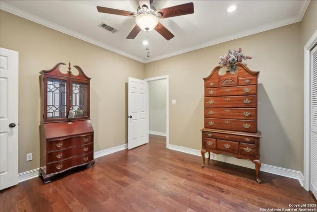 wooden floor in a room with a dresser and chandelier