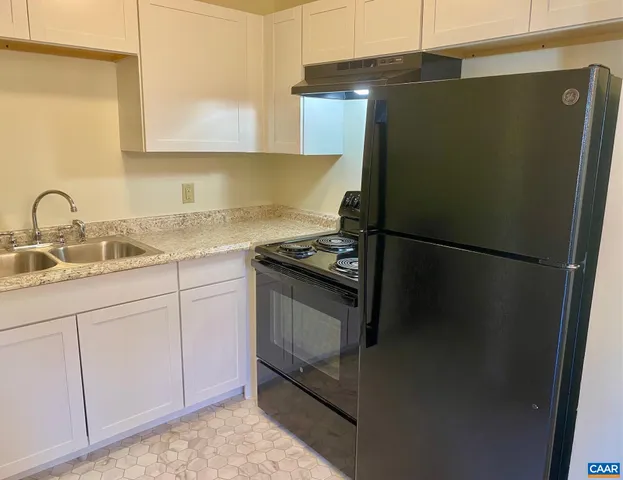 a kitchen with a refrigerator and cabinets
