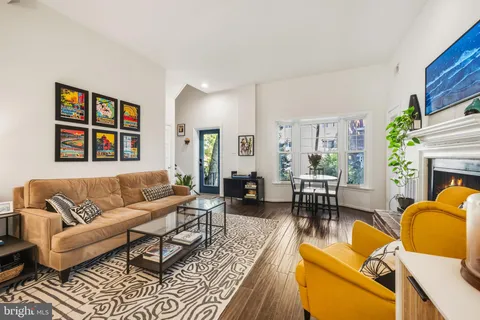 a living room with furniture fireplace and a large window