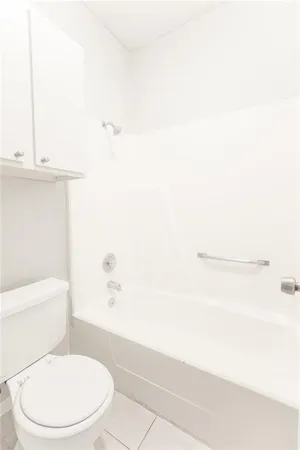 a white toilet sitting next to a bath tub