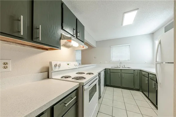 a kitchen with a stove sink and cabinets