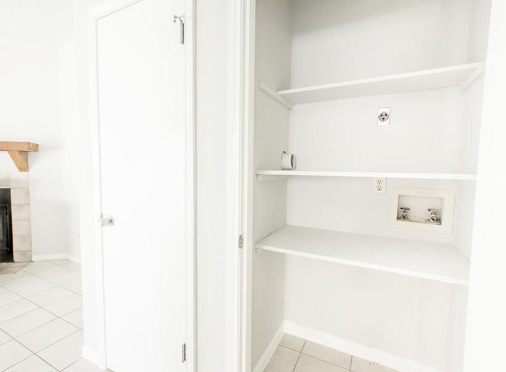 3707 Buffalo Springs Trail, Unit 301 Georgetown, TX 78628 - Photo 8 of 15 Washroom featuring light tile patterned floors, a tile fireplace, and hookup for a washing machine