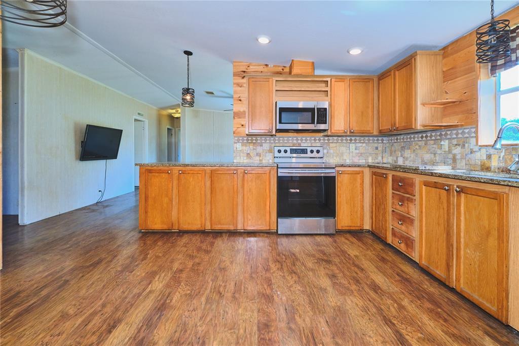 2701 Murphy Road Ona, FL 33865 - Photo 17 of 41 a kitchen with stainless steel appliances granite countertop a stove a sink and a microwave