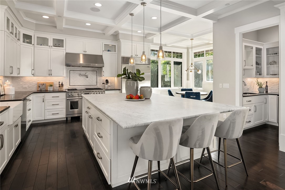 3112 Hunts Point Circle Hunts Point, WA 98004 - Photo 11 of 40 a kitchen with stainless steel appliances granite countertop a stove top oven a sink a dining table and chairs