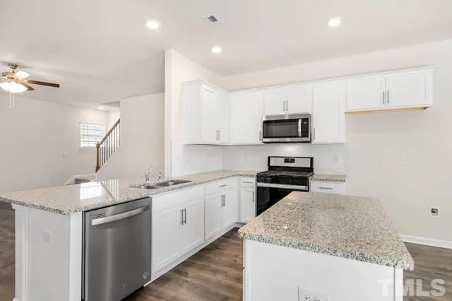 a kitchen with granite countertop white cabinets and a sink
