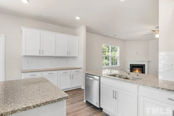 a kitchen with granite countertop white cabinets and a window