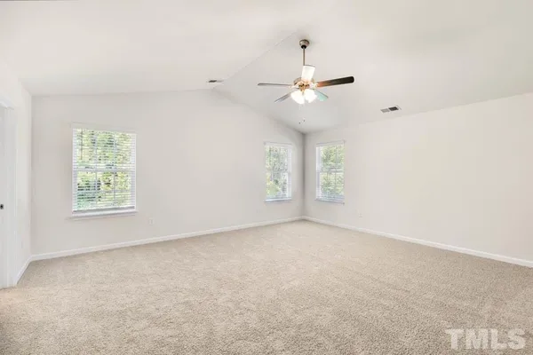an empty room with windows and fan