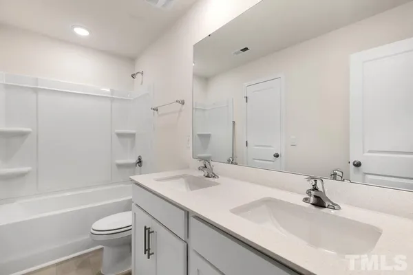 a bathroom with a granite countertop sink mirror and shower