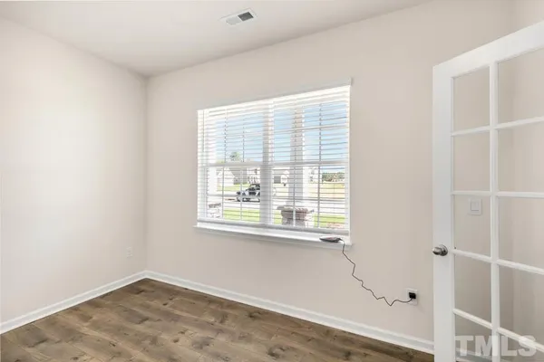 a view of an empty room with wooden floor