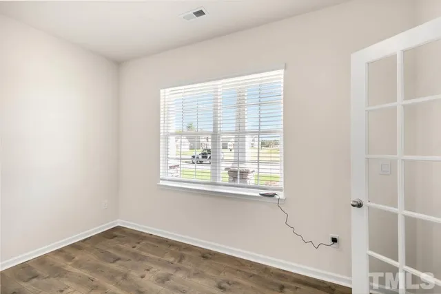 a view of an empty room with wooden floor