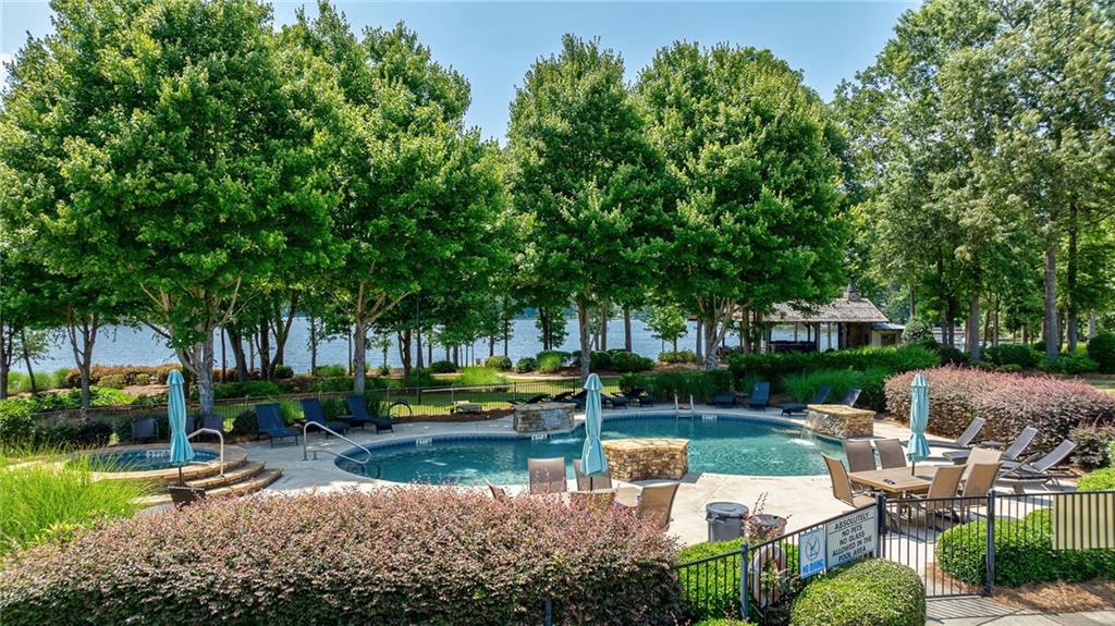 549 Old Phoenix Road Northeast, Unit 104 Eatonton, GA 31024 - Photo 37 of 48 a view of a lake with lawn chairs and large trees