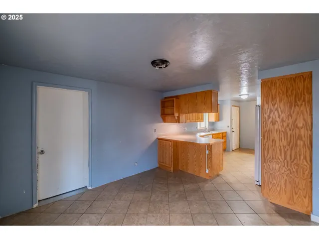 a view of empty room with a window and chandelier
