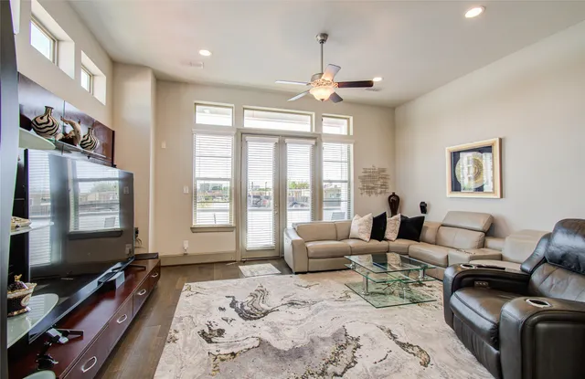 a living room with furniture a large window and a flat screen tv