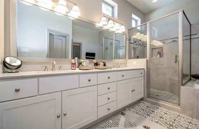 a bathroom with a tub sink shower and mirror