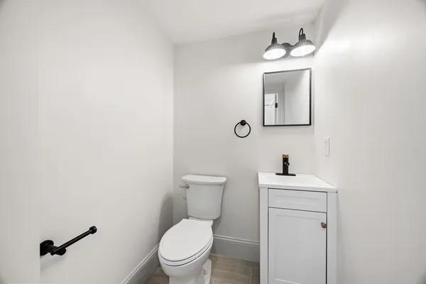 a bathroom with a toilet a sink and mirror