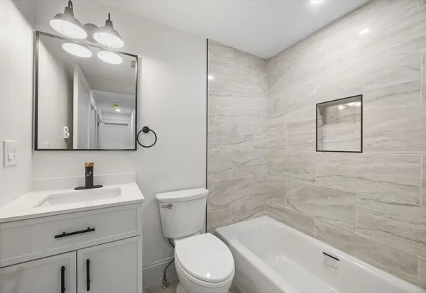 a bathroom with a toilet a sink a mirror and shower