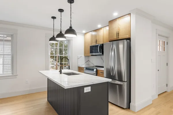 a kitchen with kitchen island a counter top space appliances and a window