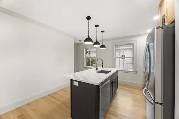 a kitchen with a sink a refrigerator and chandelier