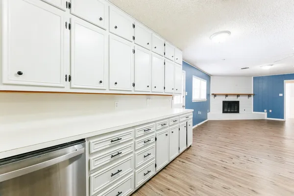 a kitchen with granite countertop a stove and a white cabinets