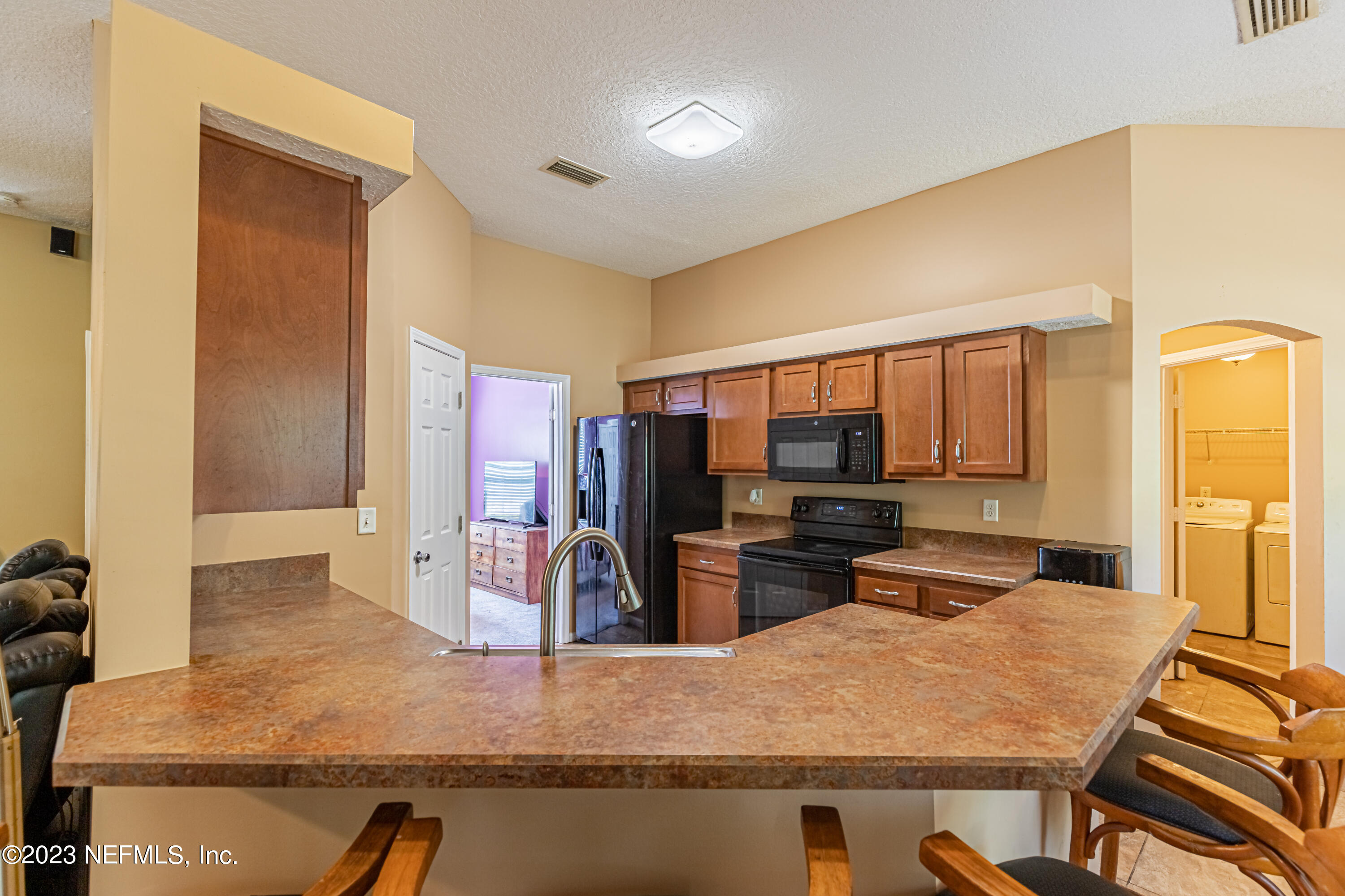 1094 Cactus Cut Road Middleburg, FL 32068 - Photo 10 of 32 a kitchen with stainless steel appliances granite countertop a sink refrigerator stove and microwave