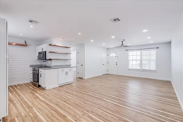 a view of kitchen with wooden floor and electronic appliances