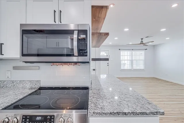 a kitchen with granite countertop a stove and a sink