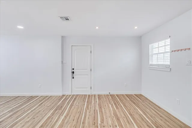 wooden floor in an empty room with a window