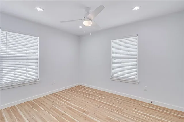 an empty room with a window and a ceiling fan
