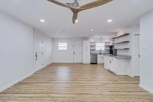 a view of kitchen view wooden floor stainless steel appliances and cabinets