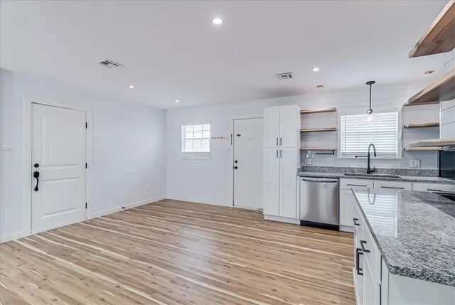 a large kitchen with kitchen island a sink stainless steel appliances and cabinets