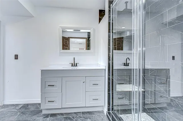 a bathroom with a shower sink and mirror