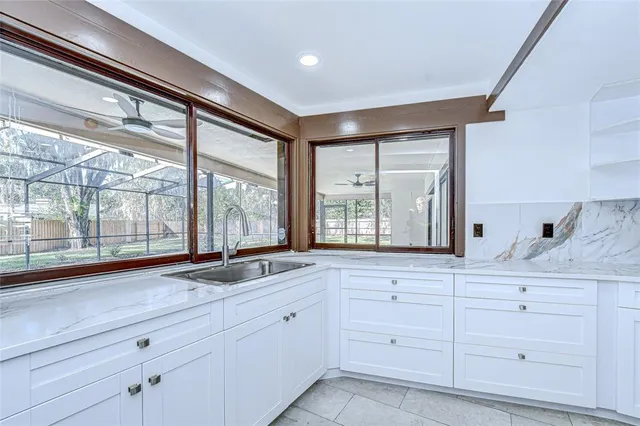 a sink with white cabinets and a wooden floor
