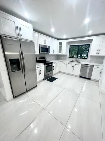 a kitchen with stainless steel appliances a refrigerator sink microwave and stove