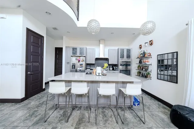 a kitchen with a dining table chairs stainless steel appliances and cabinets
