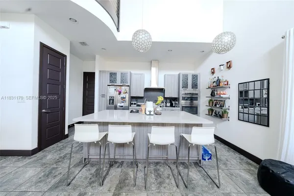 a large white kitchen with a dining table and chairs