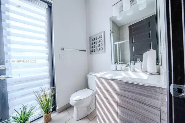 a bathroom with a granite countertop sink a toilet and a mirror
