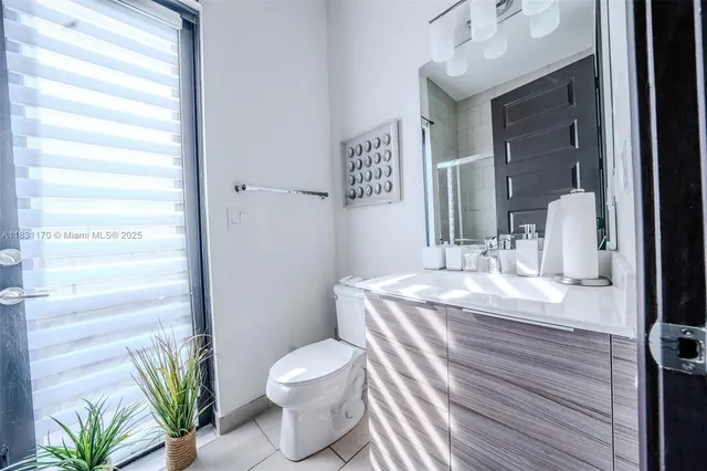 a bathroom with a granite countertop sink a toilet and a mirror