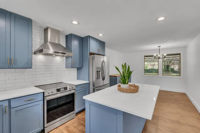 a kitchen with stainless steel appliances kitchen island a stove and a refrigerator