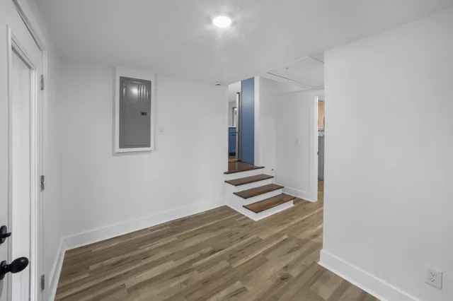 an empty room with wooden floor and white walls