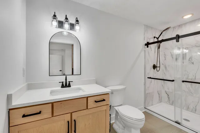 a bathroom with a sink toilet and shower