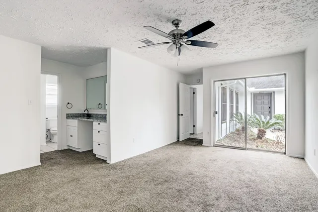 a view of a room with an empty space and a ceiling fan