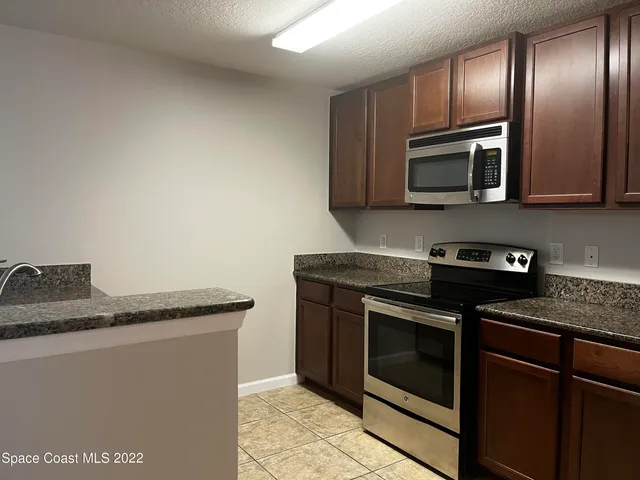 a kitchen with granite countertop stainless steel appliances and wooden cabinets