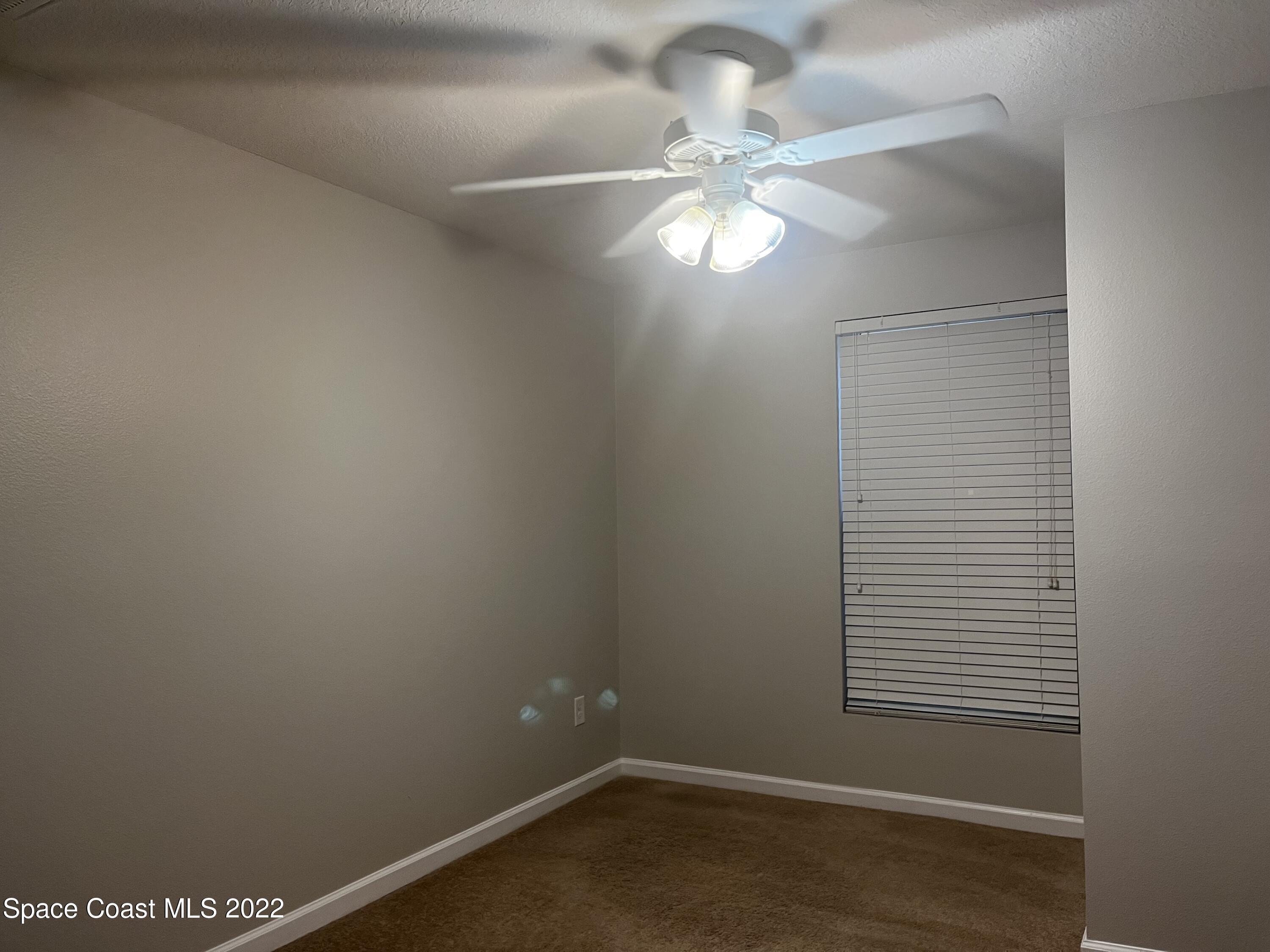 4127 Meander Place, Unit 203 Rockledge, FL 32955 - Photo 5 of 13 a view of a small space with wooden floor and a fan