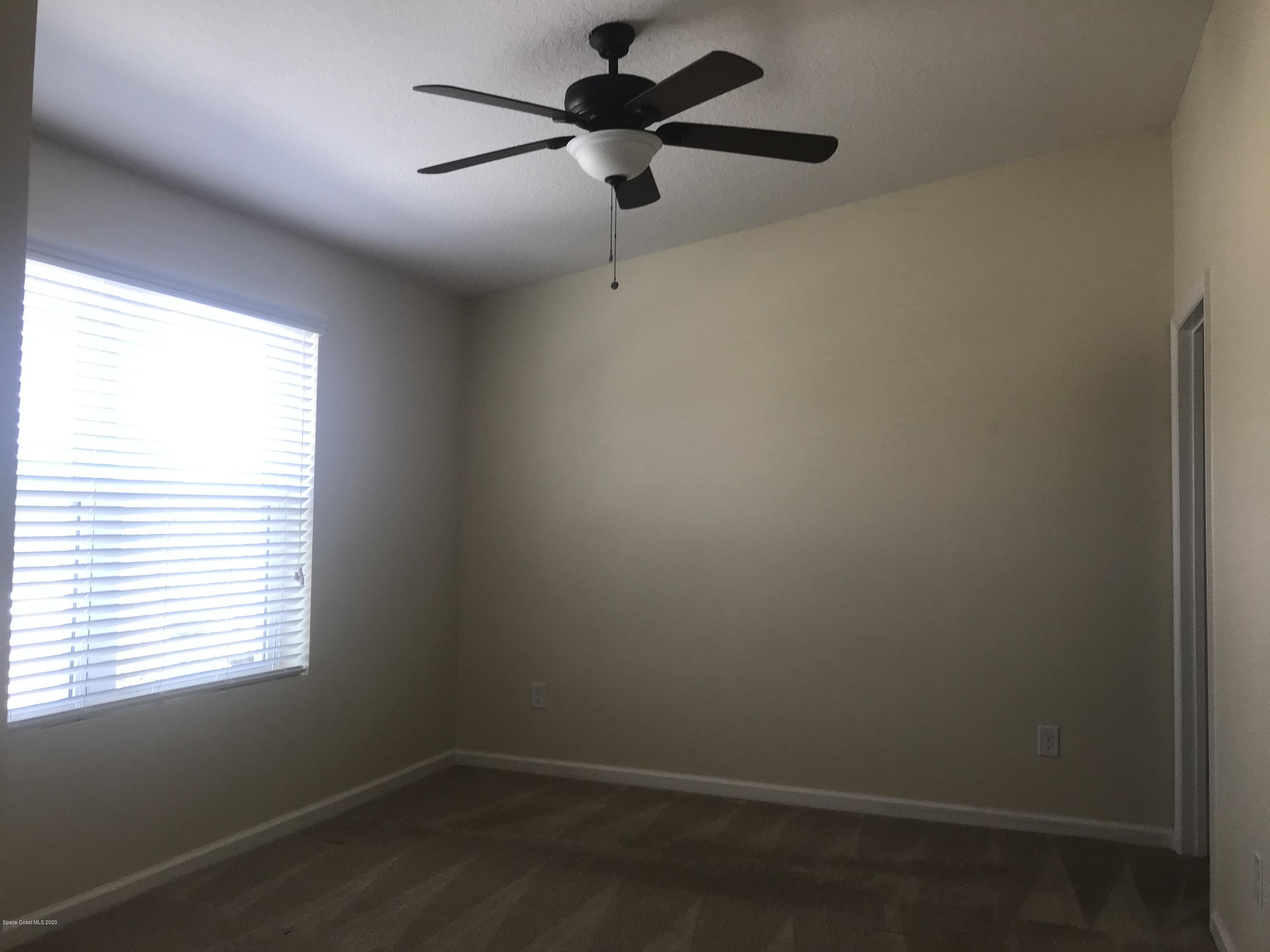 4127 Meander Place, Unit 203 Rockledge, FL 32955 - Photo 6 of 13 an empty room with a window and a fan