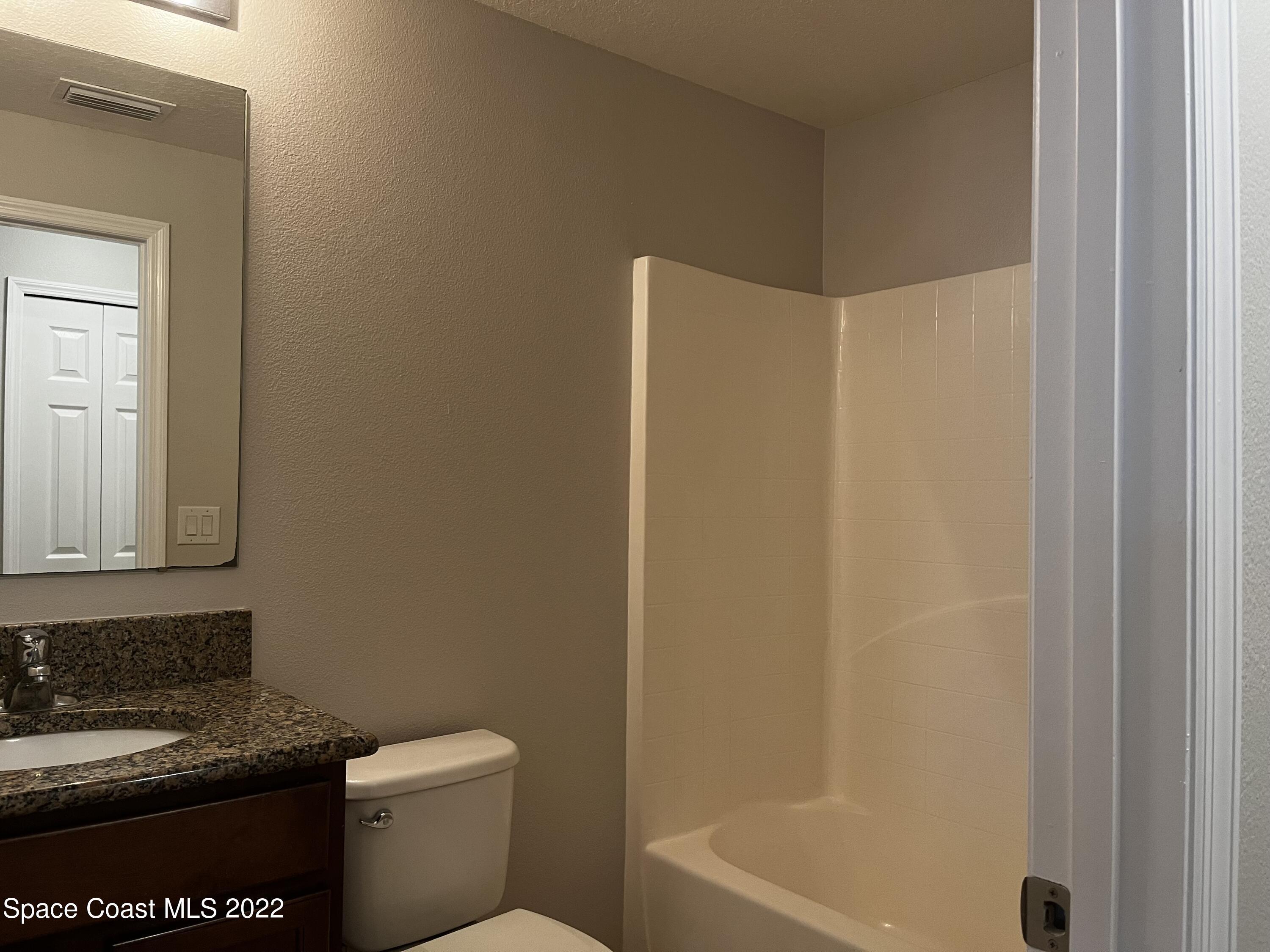 4127 Meander Place, Unit 203 Rockledge, FL 32955 - Photo 7 of 13 a bathroom with a granite countertop toilet a sink and bathtub