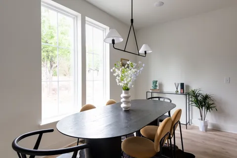 a kitchen with stainless steel appliances granite countertop a stove a kitchen island a dining table and chairs with wooden floor