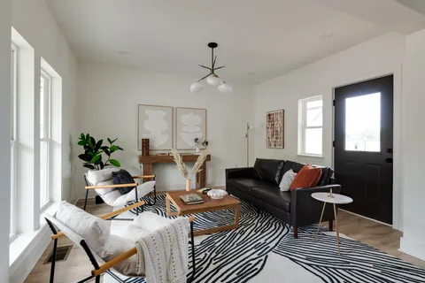 a living room with a large window and chairs