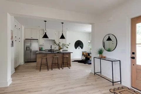 a kitchen with stainless steel appliances granite countertop a sink a stove and chairs
